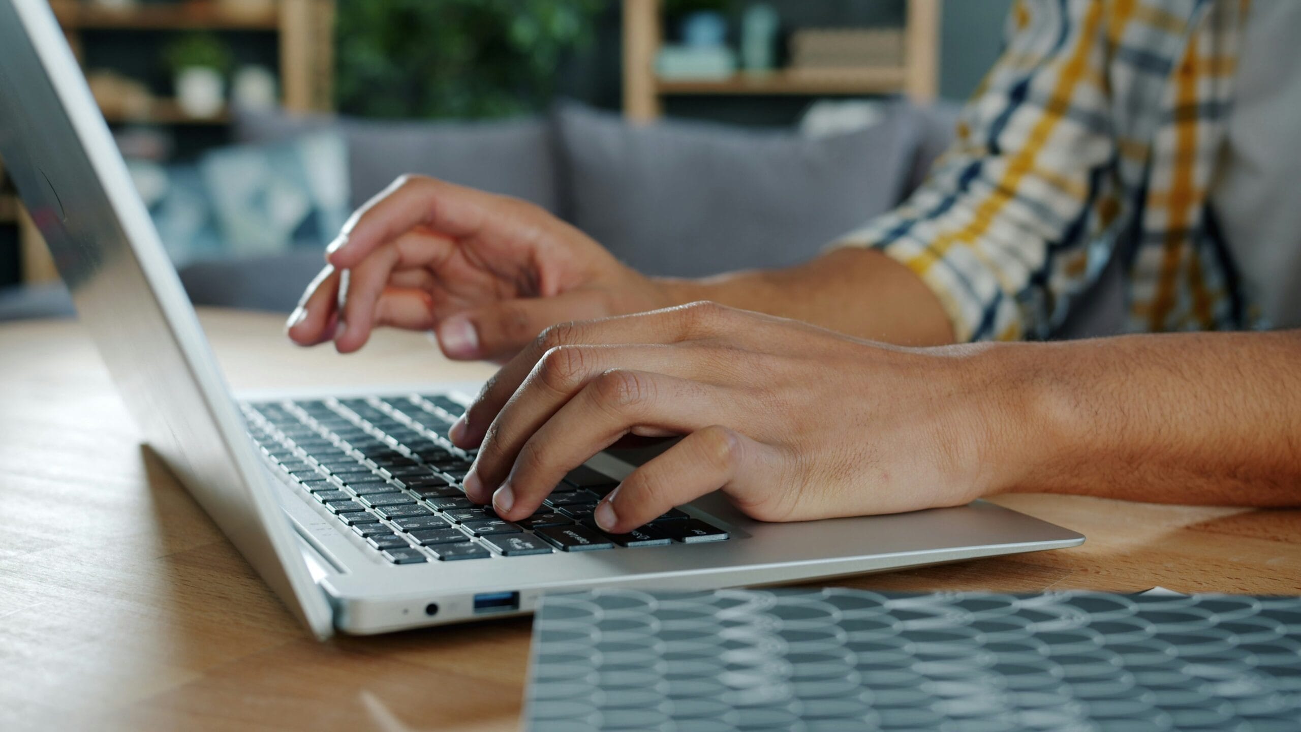 Hands typing on a quiet wireless keyboard in a home office