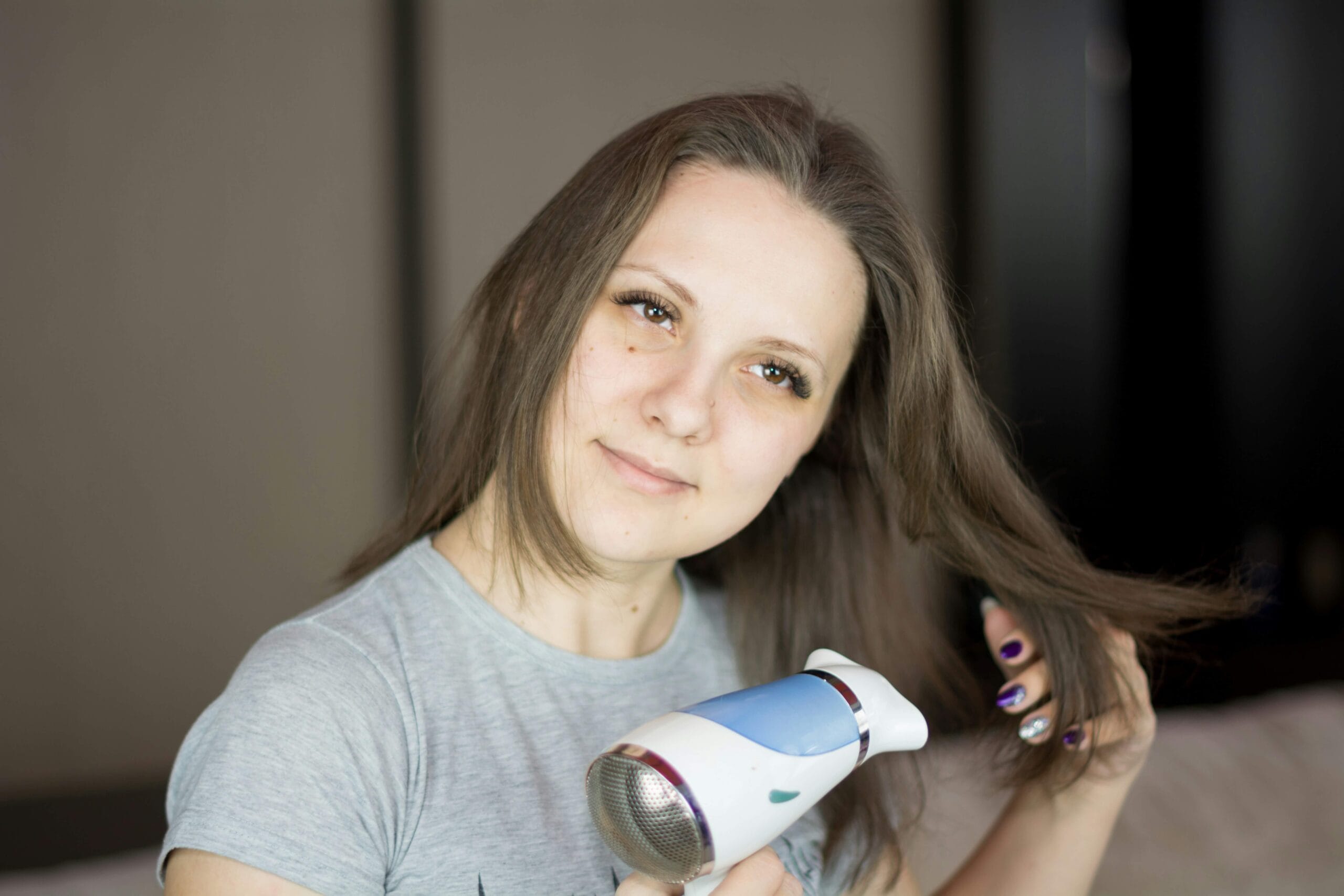 Woman using a quiet hair dryer in a bathroom mirror