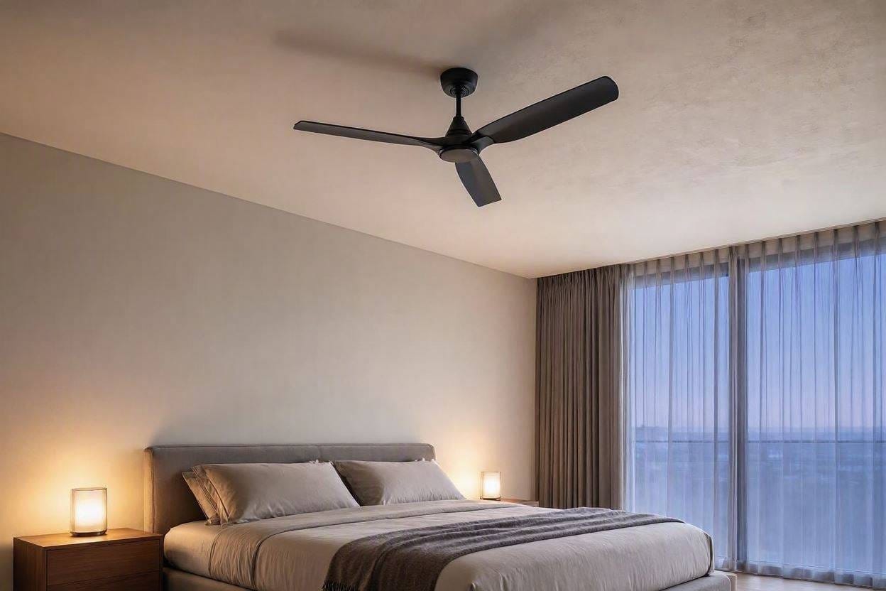 A sleek, modern quiet ceiling fan installed in a peaceful, dimly lit bedroom