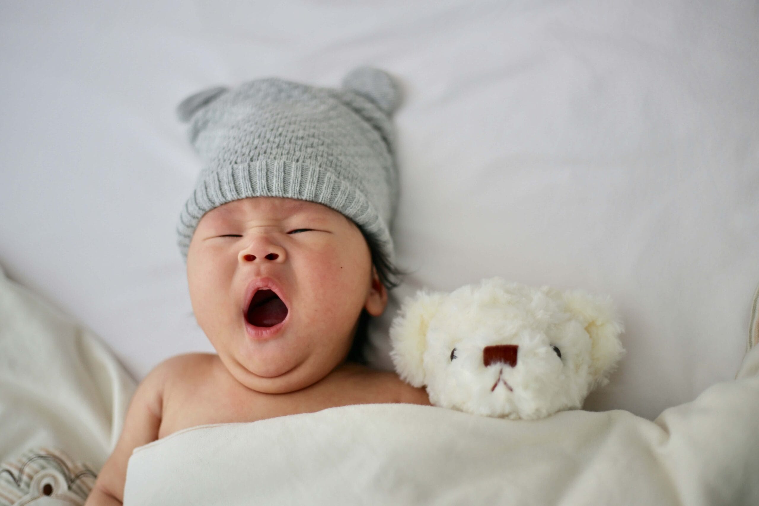 A peaceful infant sleeping soundly in a nursery utilizing acoustic masking and pink noise to block environmental sounds.